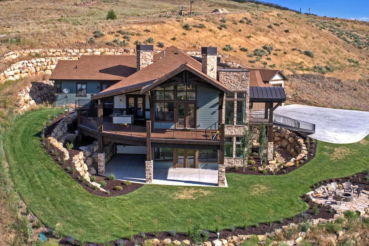 House plan exterior: Modern Mountain style, two stories, expansive deck, stone accents, and large windows.