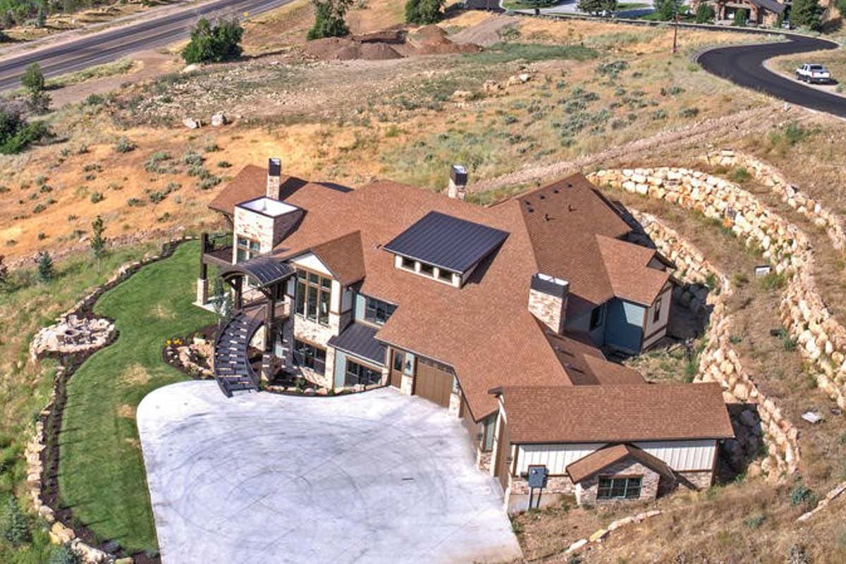 House plan exterior featuring multiple gables, a prominent dormer, and a curved entrance staircase.