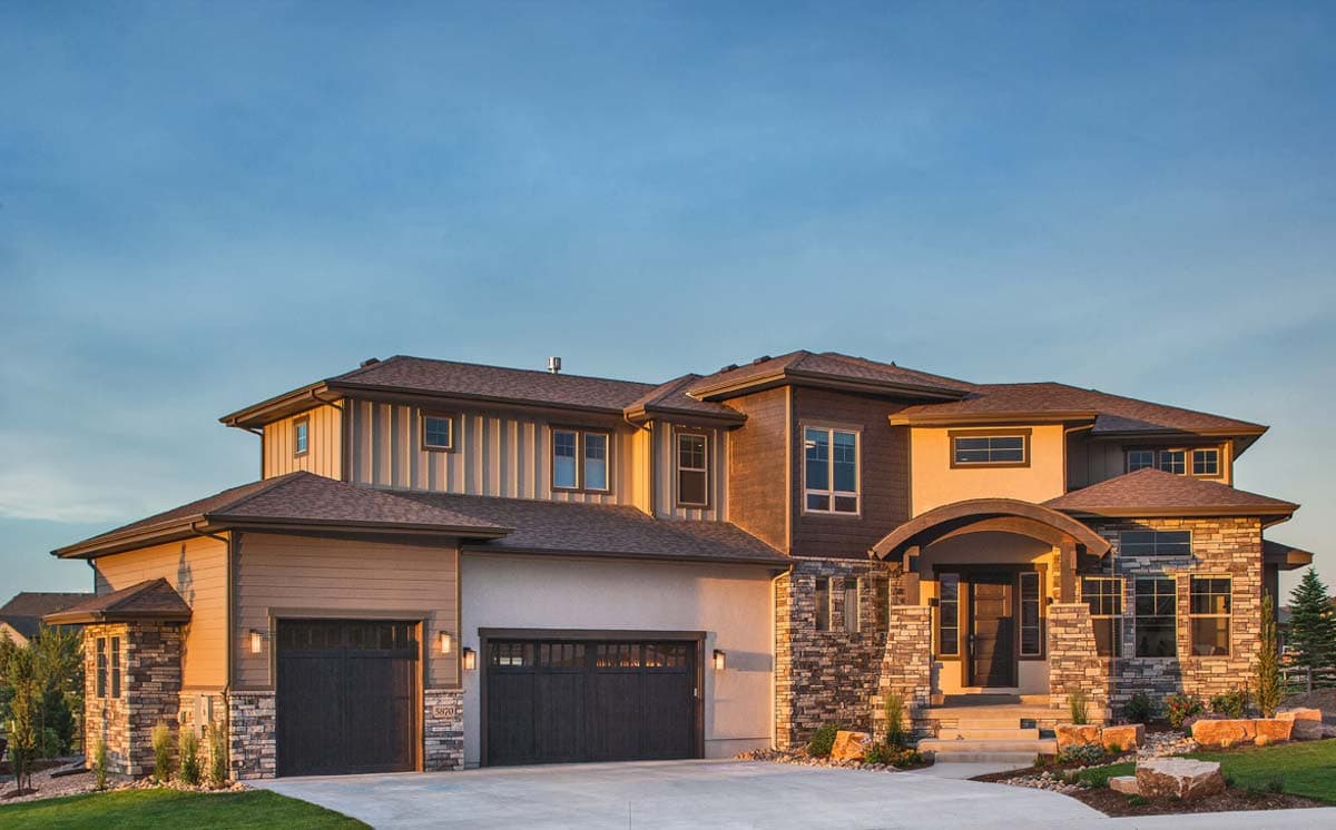 House plan exterior: Two-story home with stone accents, arched entry, and a three-car garage.