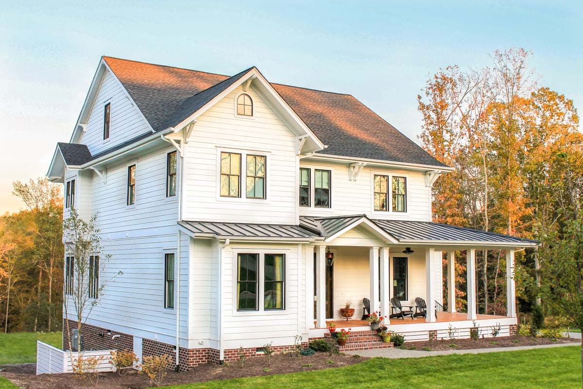 Modern Farmhouse house plan exterior, two stories, featuring a wrap-around porch, prominent gables, and board and batten siding.