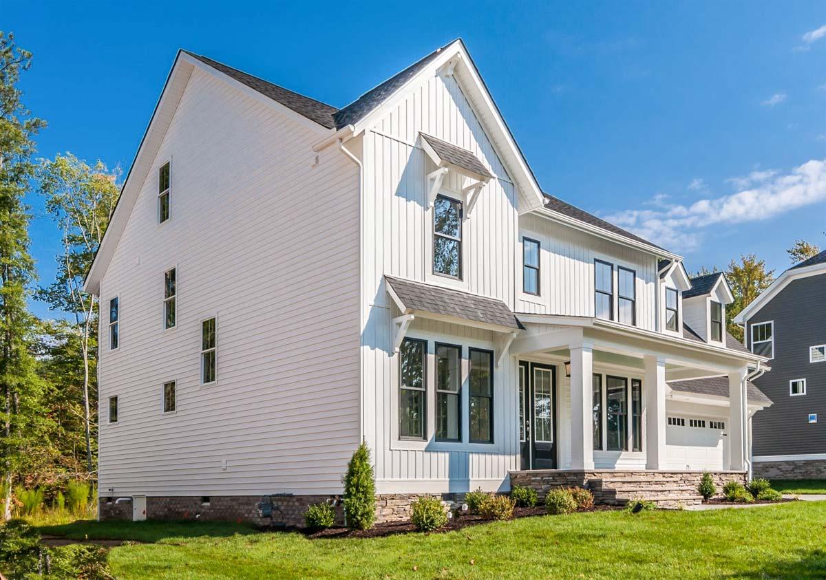 Modern Farmhouse house plan exterior, two stories, white board-and-batten siding, prominent gable, covered porch, and attached garage.