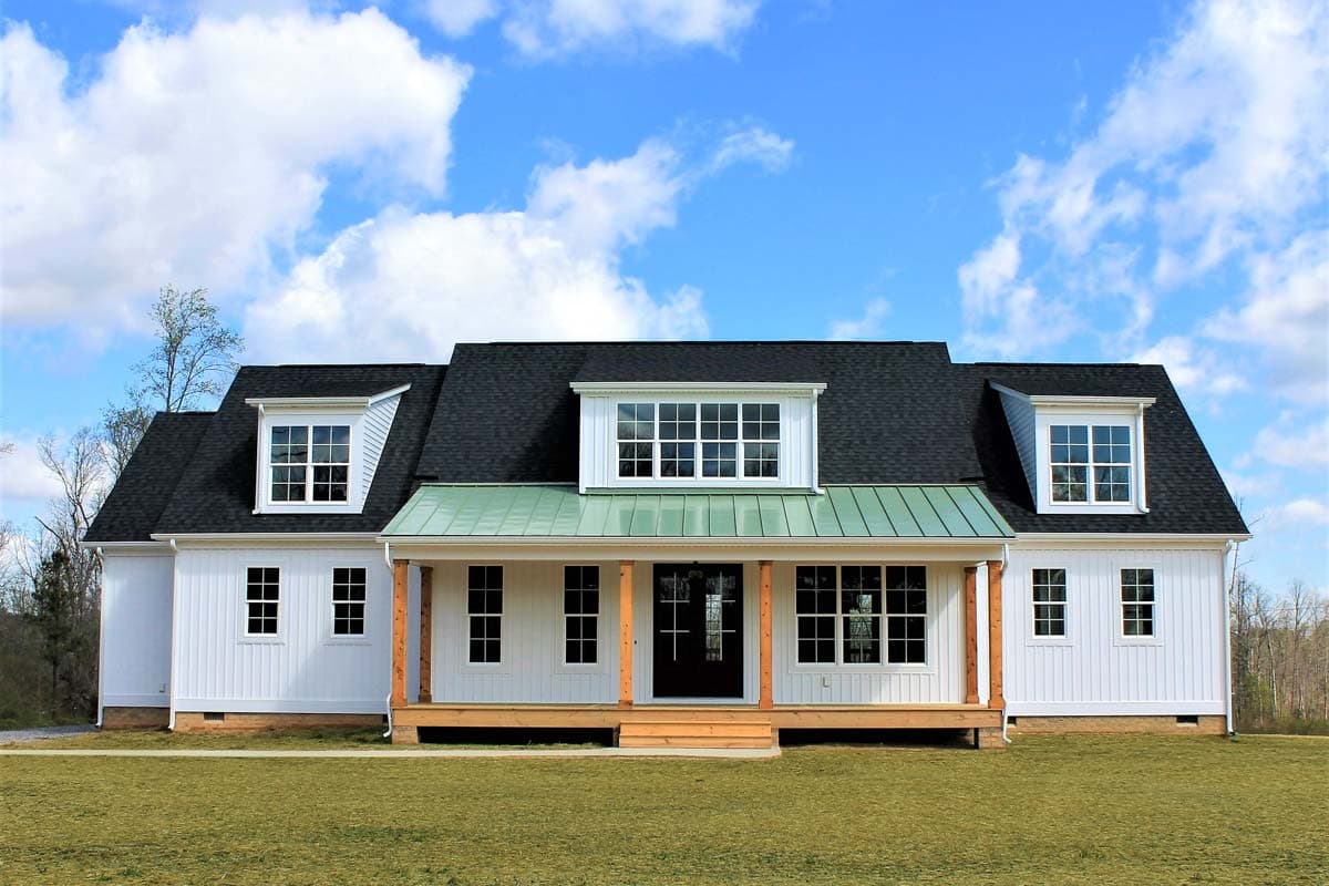 House plan exterior. Two-story Modern Farmhouse with dormers, front porch, and standing seam metal roof over the porch.