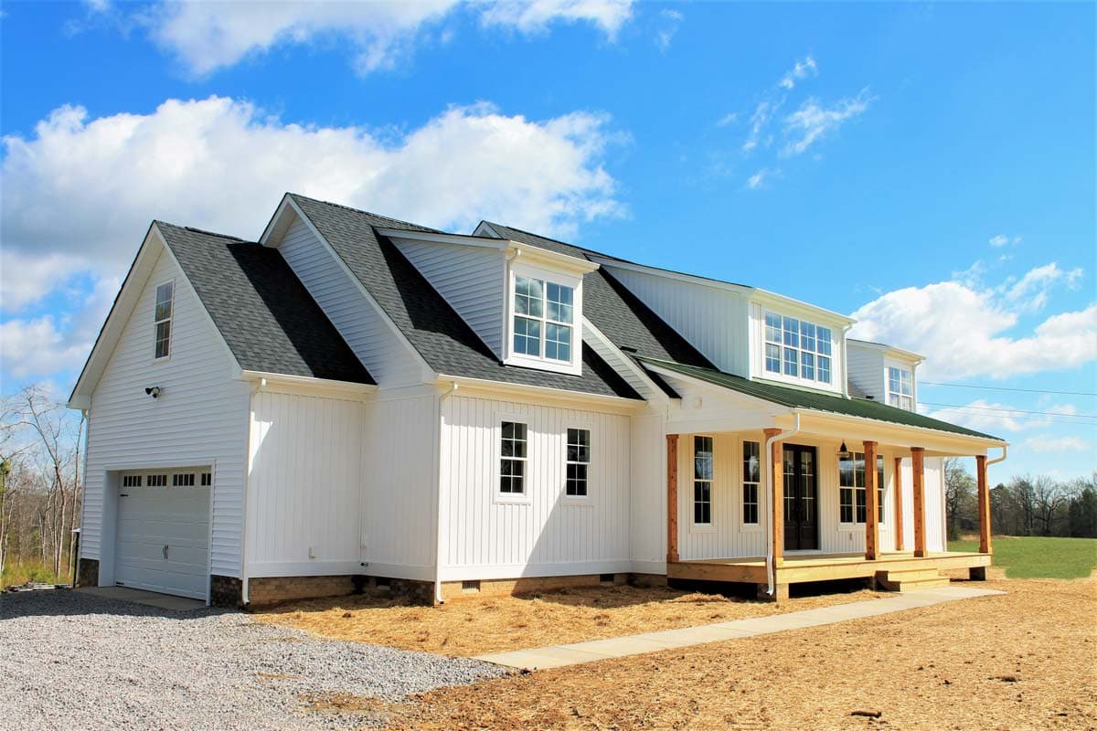 Modern Farmhouse house plan exterior with gabled dormers, a covered porch with wood posts, and a side-entry garage.