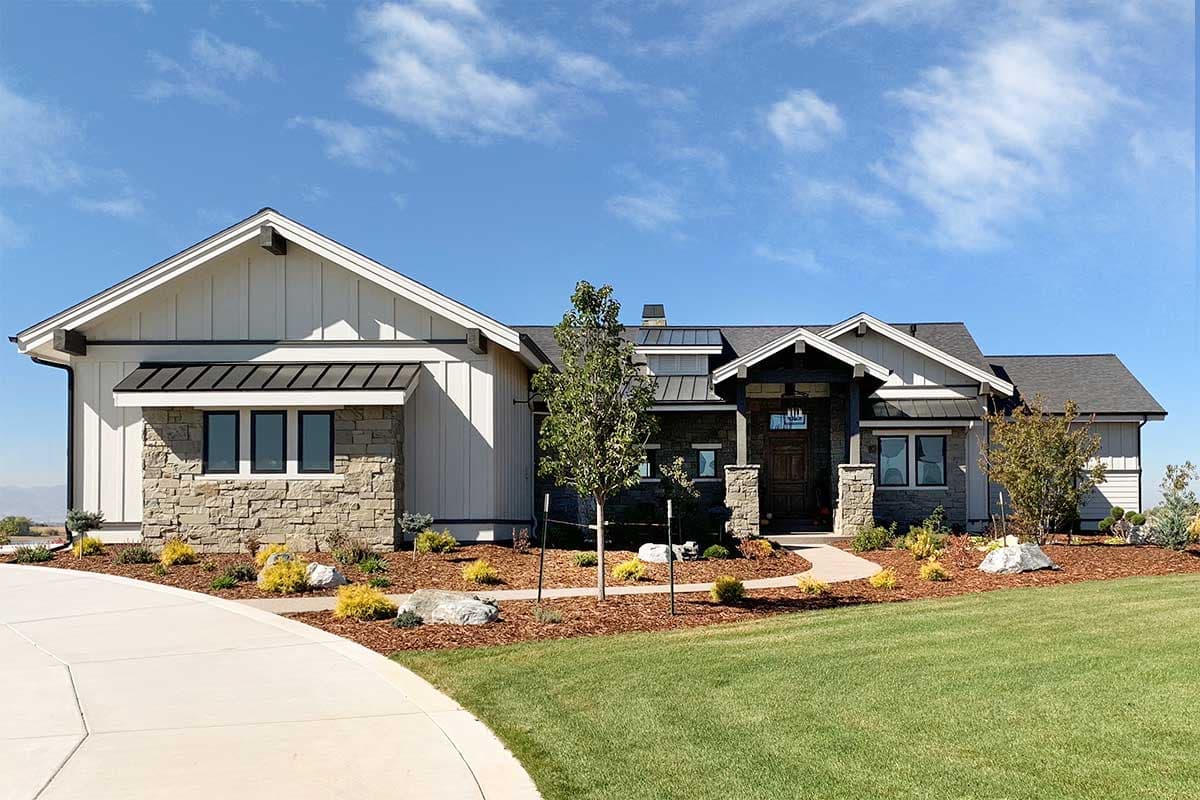 House plan exterior. Modern Farmhouse style with board-and-batten siding, stone accents, gabled roof, and covered entry porch.