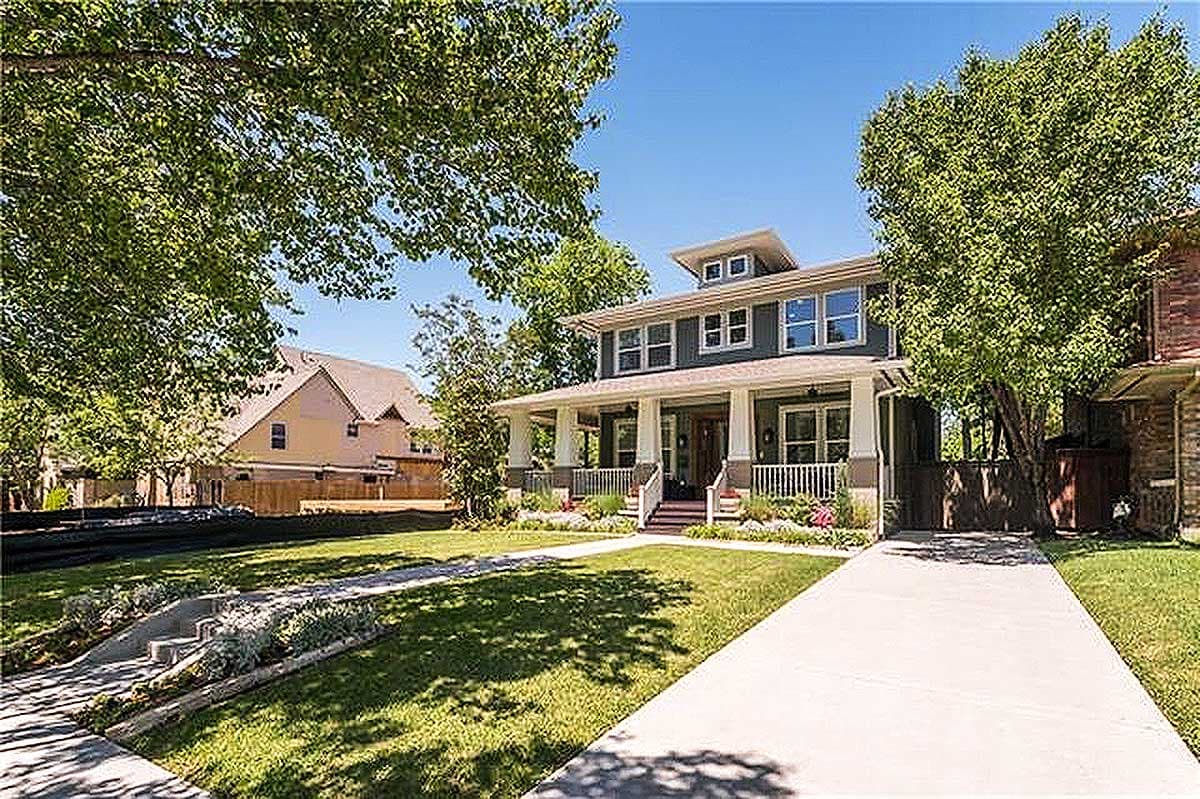 Craftsman-style house plan exterior: two stories, wrap-around porch, dormers, and multiple gables.