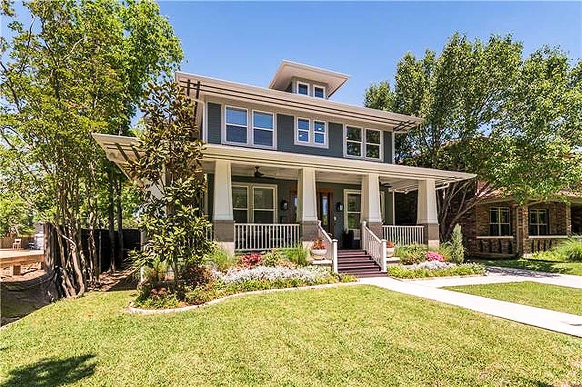 Two-story Modern Craftsman house plan with a wide wraparound porch, prominent gables, and a flat roofline.