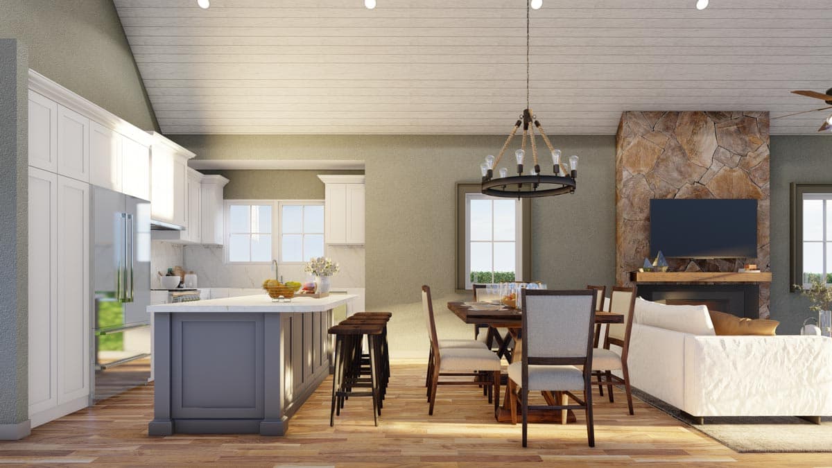 Open-concept living space with kitchen island, dining area, and great room featuring a stone fireplace and vaulted ceiling.