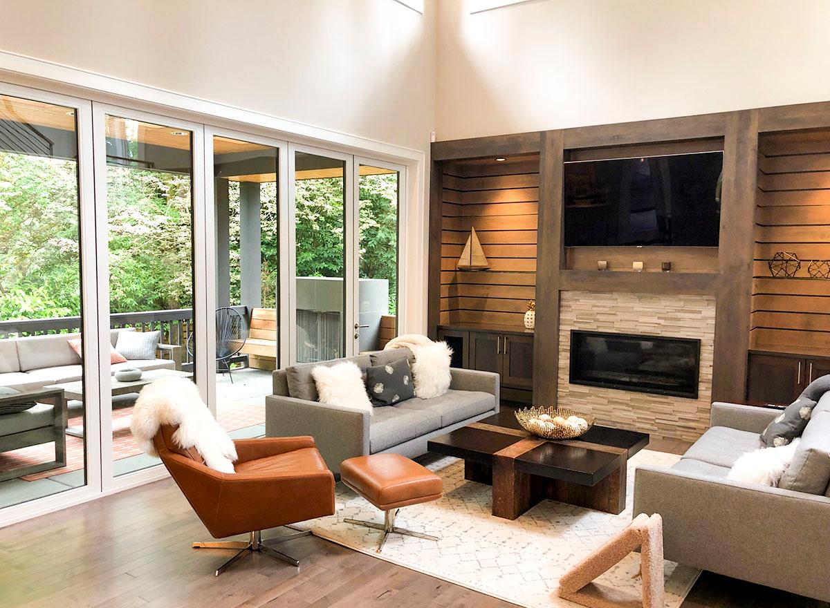 Living room interior with fireplace, built-in shelving, entertainment center, and large sliding glass doors to an outdoor patio.