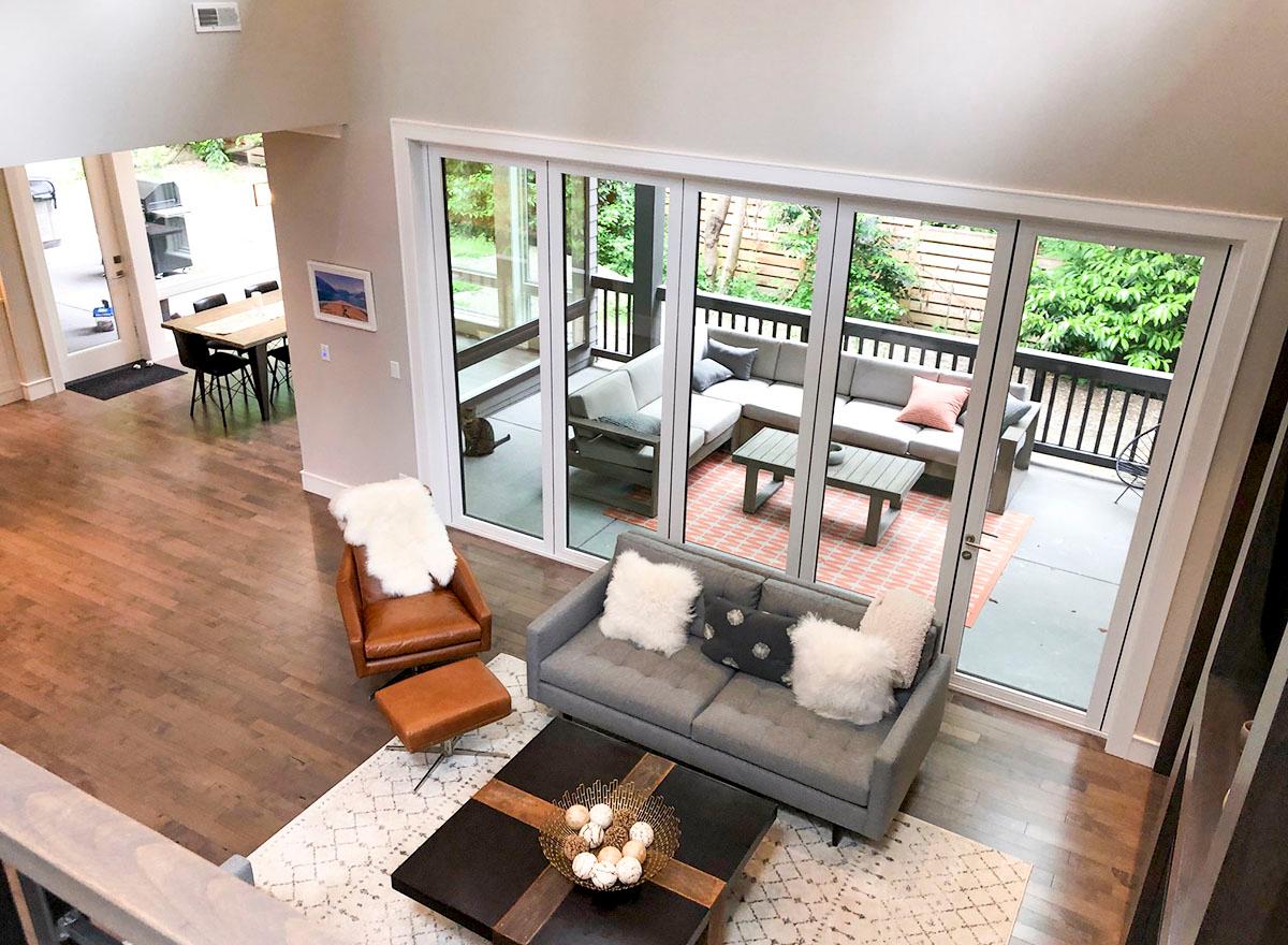 Interior view showing living area with sliding glass doors to patio, sectional seating, coffee table, and dining area beyond.