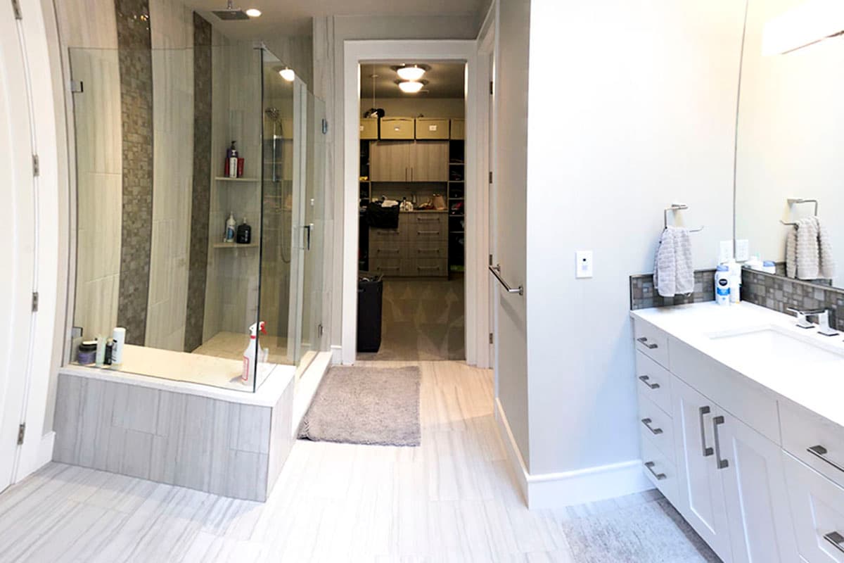 Bathroom with glass-enclosed shower, dual vanity, and walk-in closet.