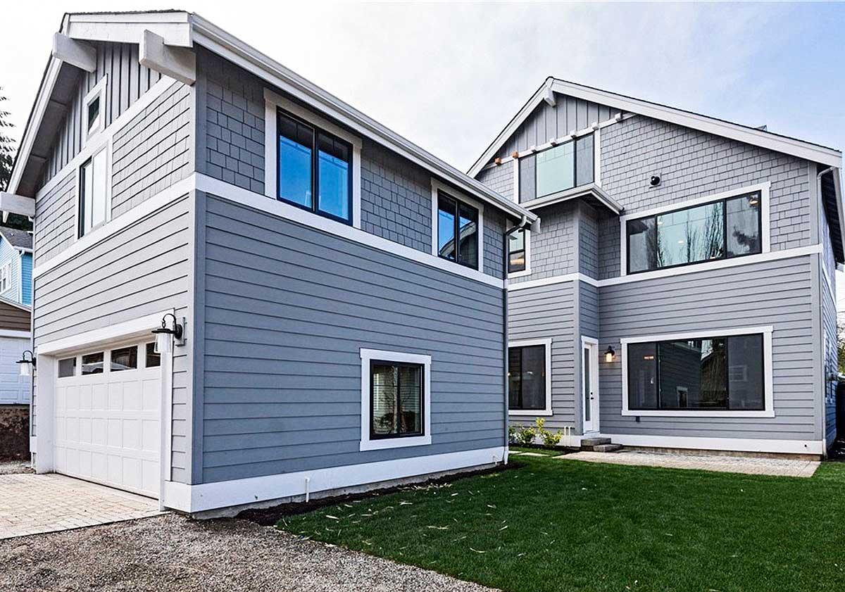 House plan exterior with two stories. Features include gable rooflines, horizontal siding, shake siding accents, and a front-facing garage.