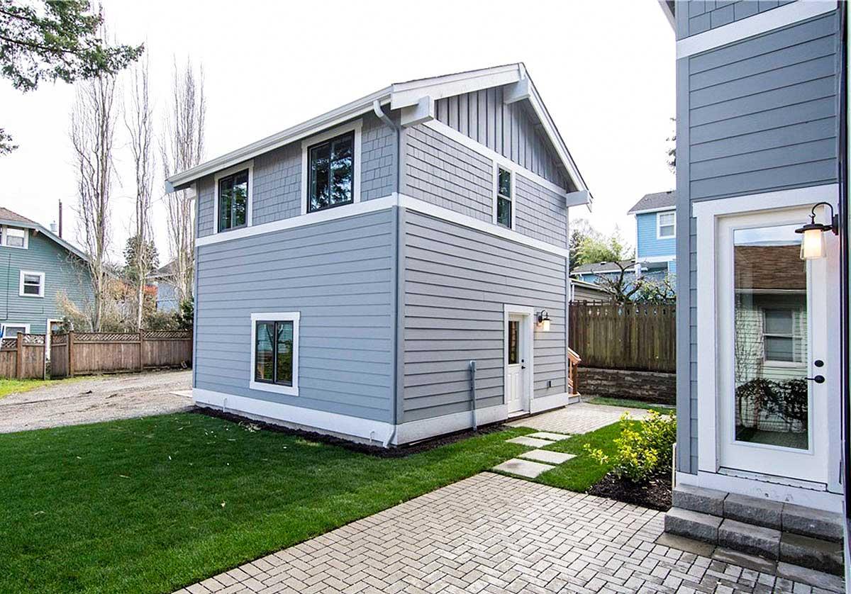 House plan exterior, two stories, horizontal siding, shingle siding accents, gable roof, and dormer windows.