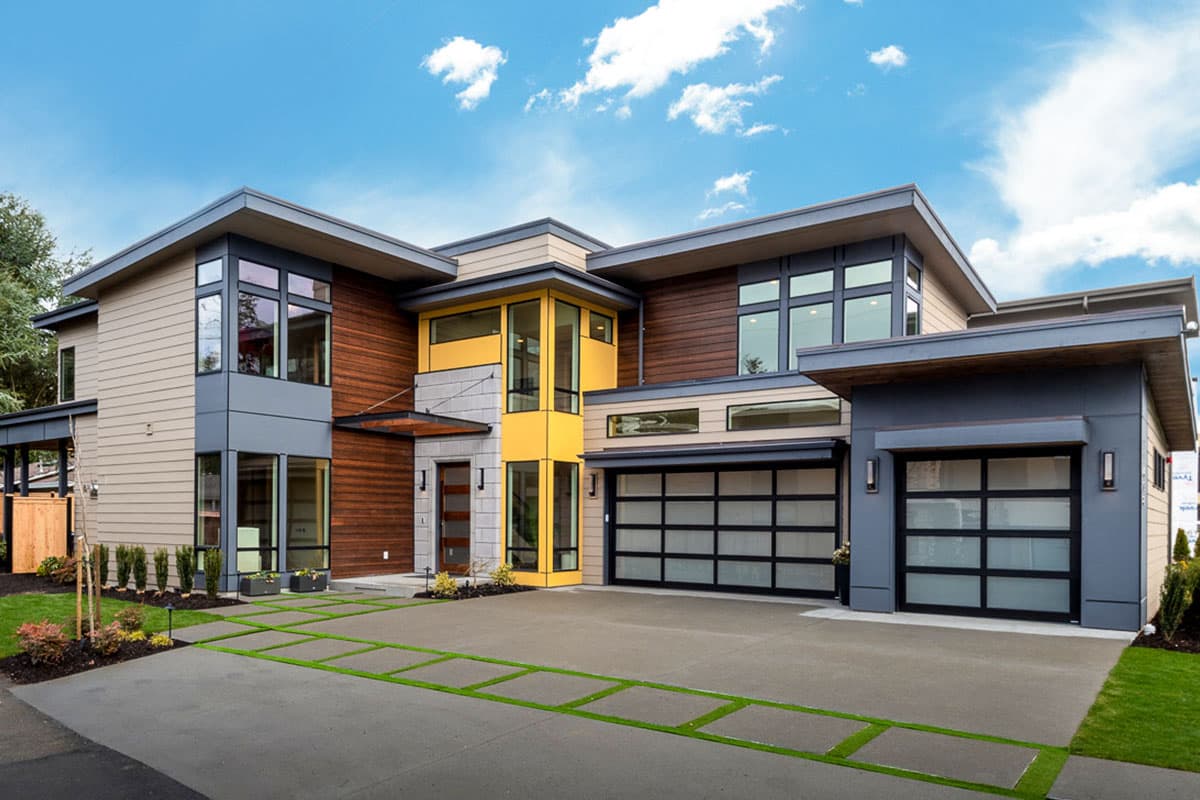 Modern house plan exterior with two stories. Features flat rooflines, large windows, and a glass-paneled garage door.