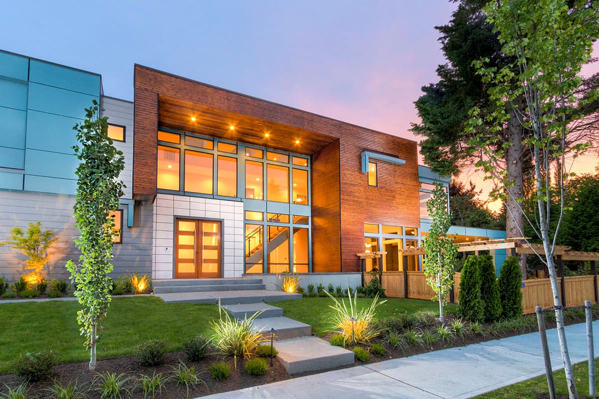 Modern house plan exterior with wood and glass facade, large windows, double doors, and multiple rooflines.