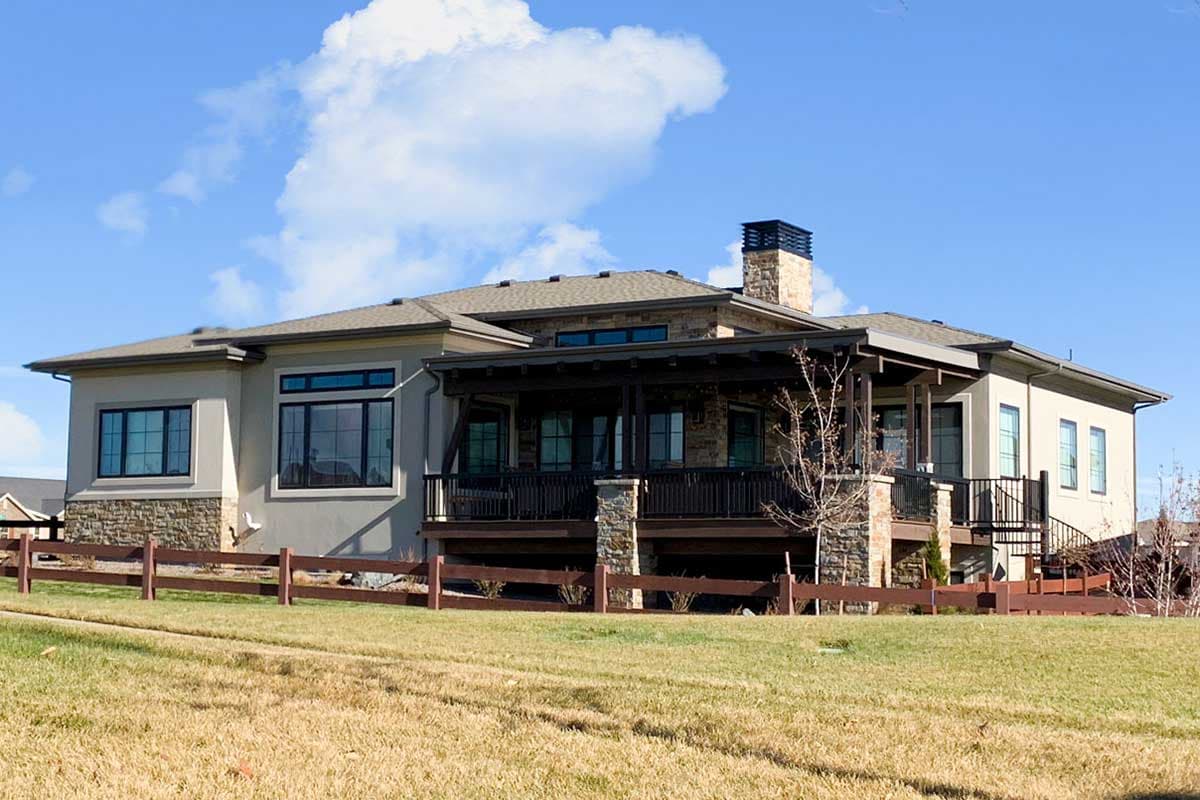 House plan exterior: Single-story home with stone accents, covered porch, and stone chimney.