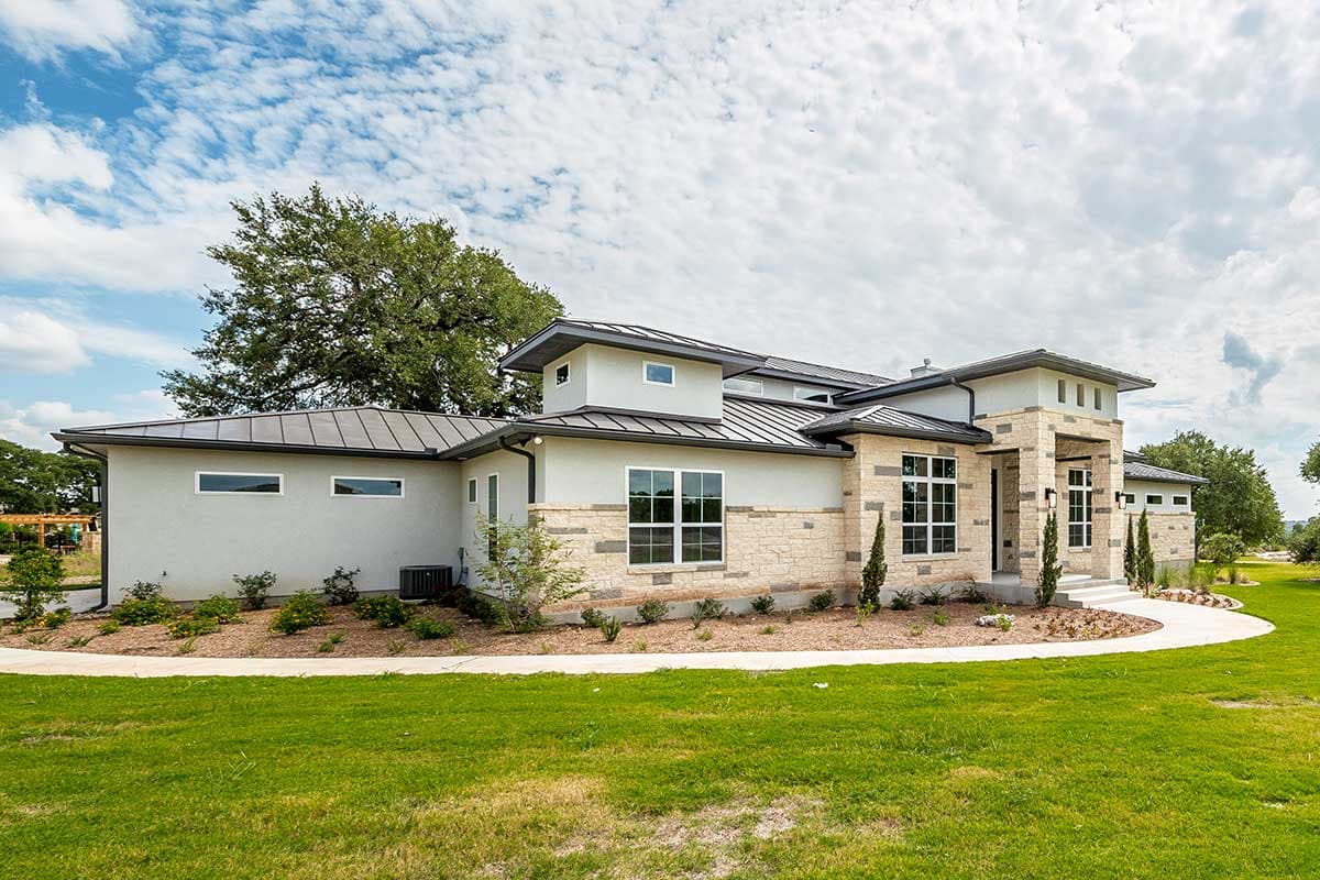 House plan exterior of a one-story modern house with stone accents, metal roof, and multiple gables.