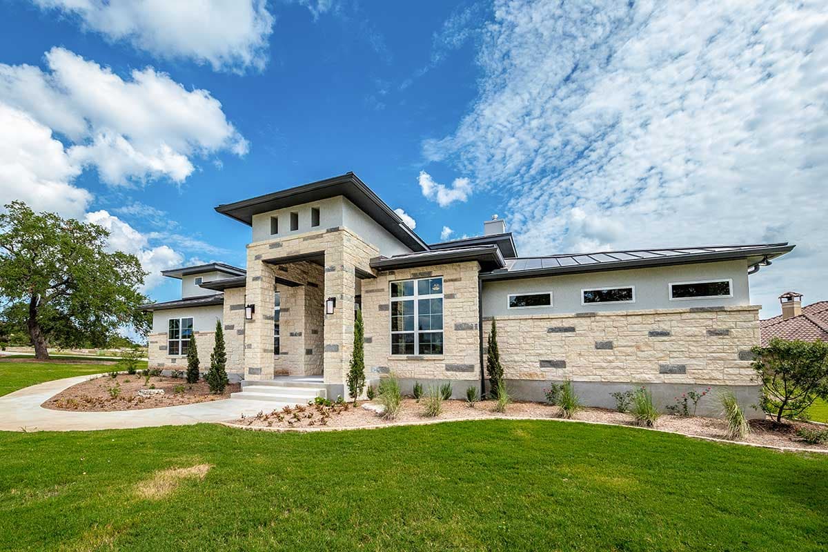 Modern house plan exterior with stone facade, layered rooflines, and a prominent covered entry with stone pillars.