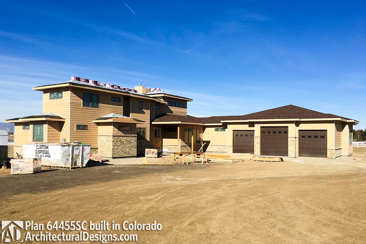 Exterior house plan: two-story home with stone accents, hip roofs, and a three-car garage.