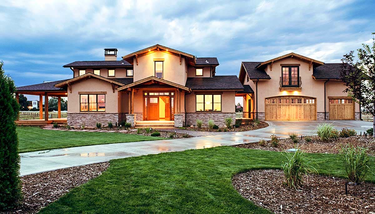 House plan exterior. Two-story home in Craftsman style. Features include a covered porch, gabled rooflines, and a three-car garage.