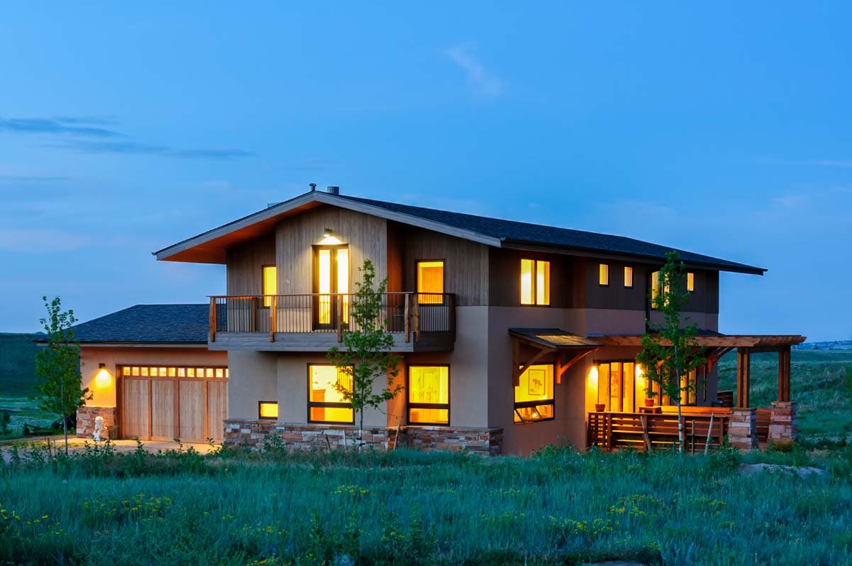 House plan exterior featuring a two-story Modern Farmhouse design with a visible garage, balcony, and covered patio.