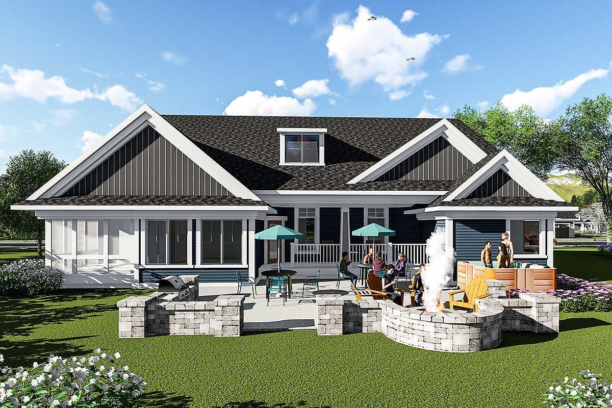 House plan exterior: Ranch style with multiple gables, dormer, wide porch, and outdoor kitchen/fire pit area.