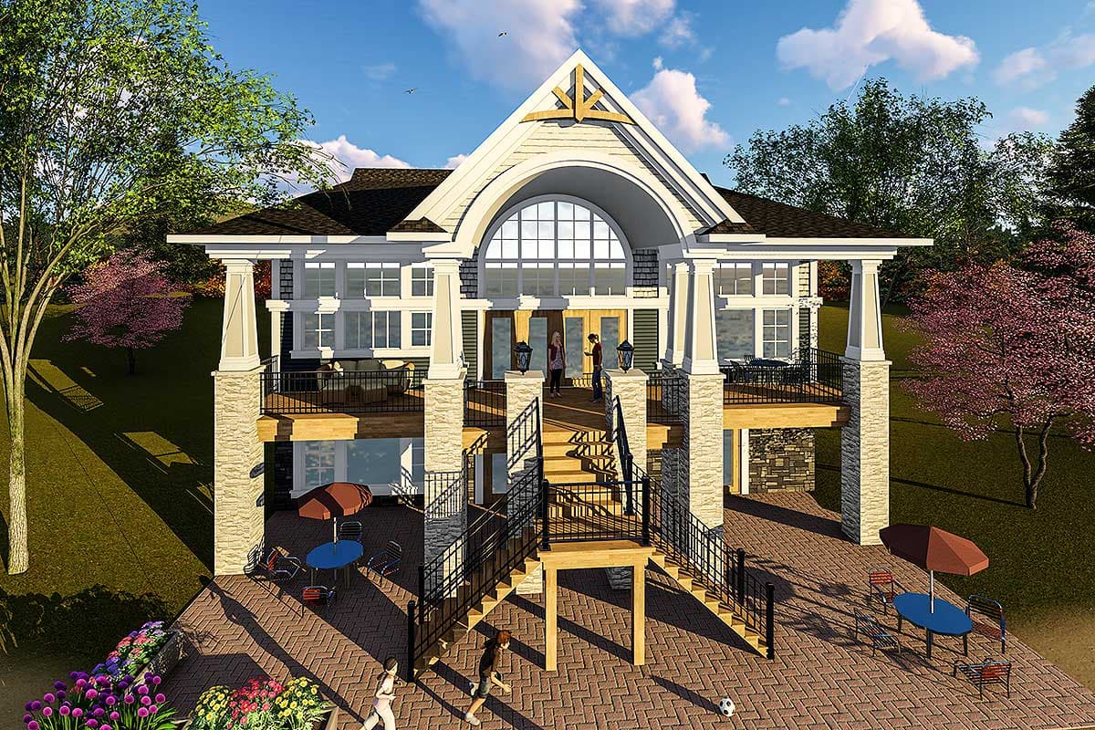 House plan exterior: two-story home with large arched window, multiple decks, and stone accent pillars.