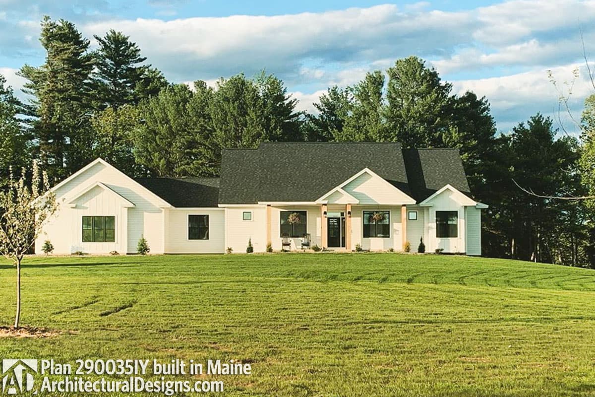 House plan exterior: Modern Farmhouse style, one story, with gables, large windows, and a covered entry porch supported by wood posts.