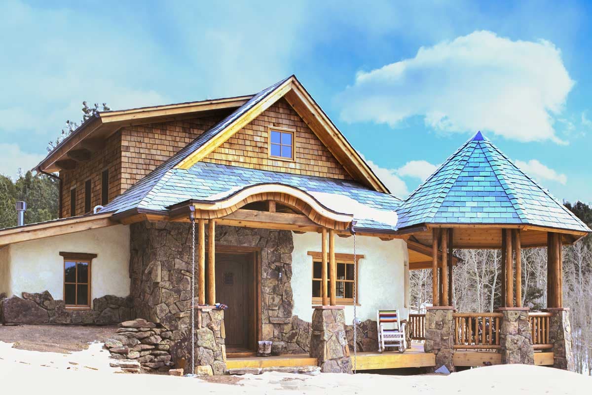 House plan exterior featuring stone foundation, wood shingle siding, curved rooflines, and a hexagonal gazebo.