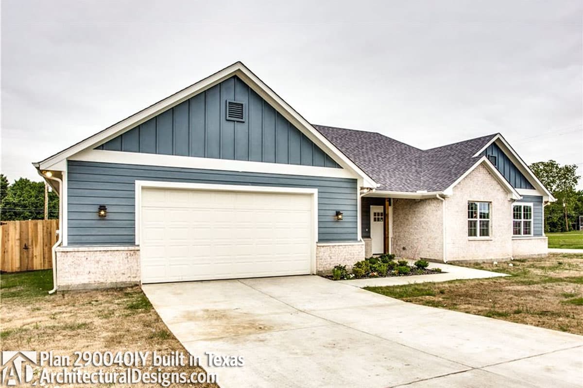 House plan exterior: One-story Modern Farmhouse with vinyl siding, brick accents, gabled roof, and attached garage.