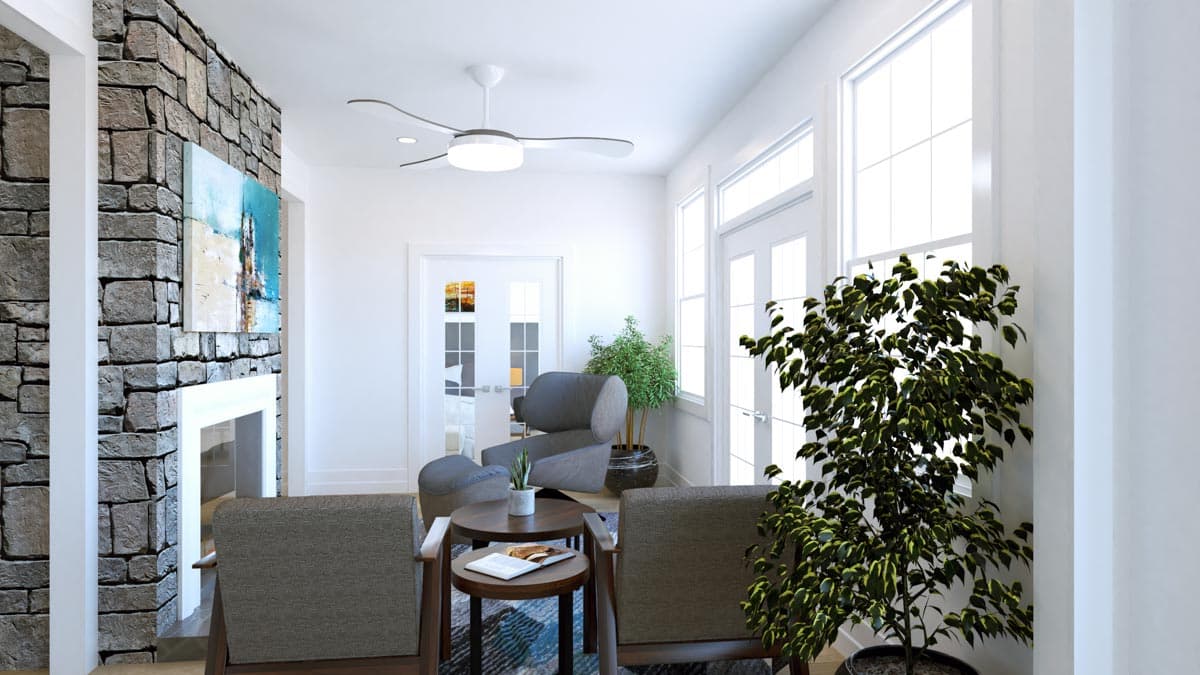 Living room with stone fireplace, seating area, and large windows.