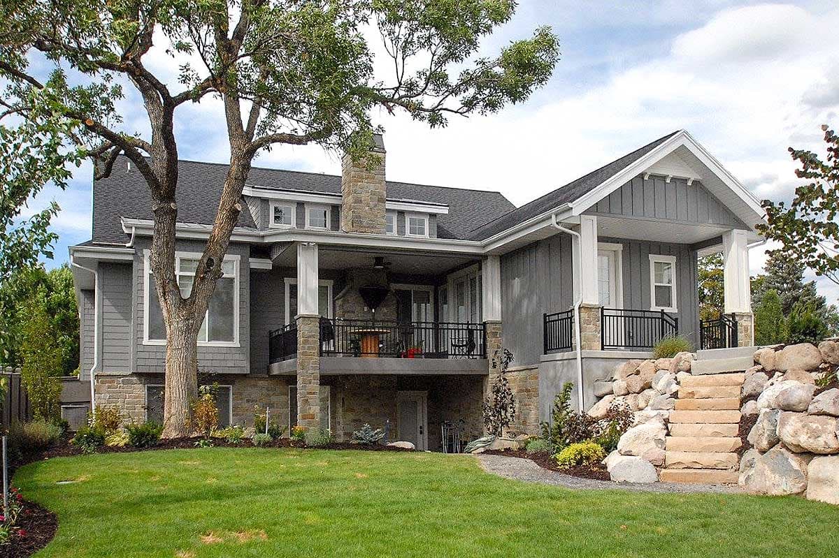 House plan exterior, two stories, Modern Farmhouse style, covered porch with stone chimney, gabled dormers, and stone foundation.