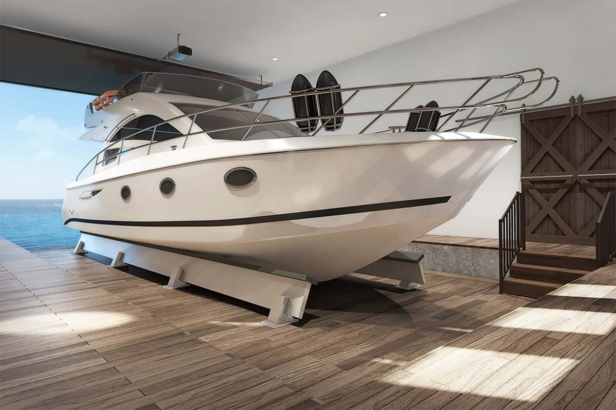 Luxury yacht on a trailer inside a modern boathouse with wooden flooring and sliding barn doors.