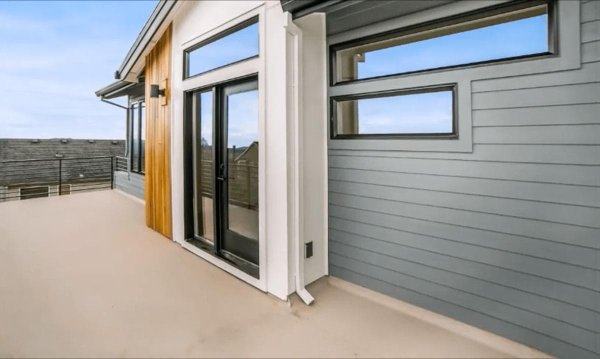Modern house exterior with horizontal siding, vertical wood accent, and horizontal band windows.