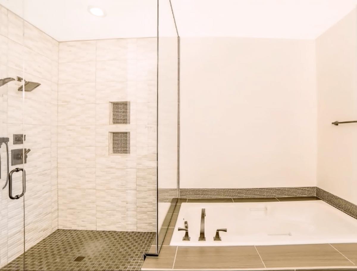 Bathroom featuring a glass-enclosed shower with tiled walls and floor, and a built-in bathtub.