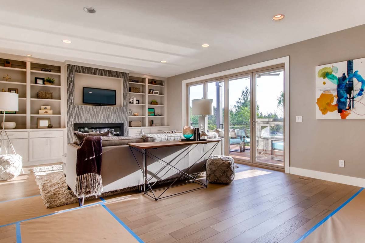 Living room with fireplace, built-in shelves, and sliding glass doors to balcony.