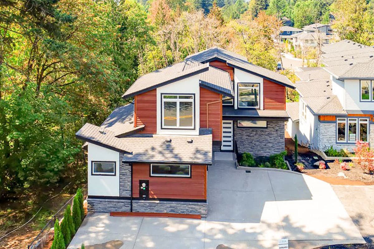 Modern house plan exterior with mixed materials, multiple gables, and large windows.