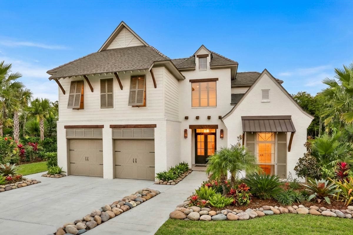 House plan exterior featuring a two-story structure, dual garage doors, arched windows with shutters, and prominent gables.