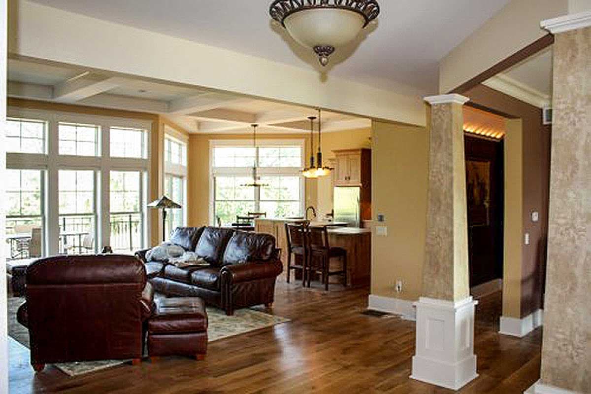 Interior view showing an open layout with a living area, kitchen island, and decorative ceiling beams.