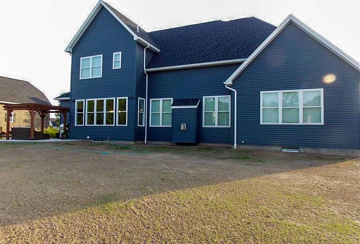 House plan exterior of a two-story home with blue siding, multiple gables, and numerous large windows.