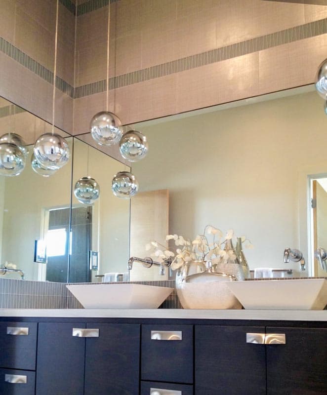 Modern bathroom vanity with dual vessel sinks, contemporary faucets, and pendant lighting.