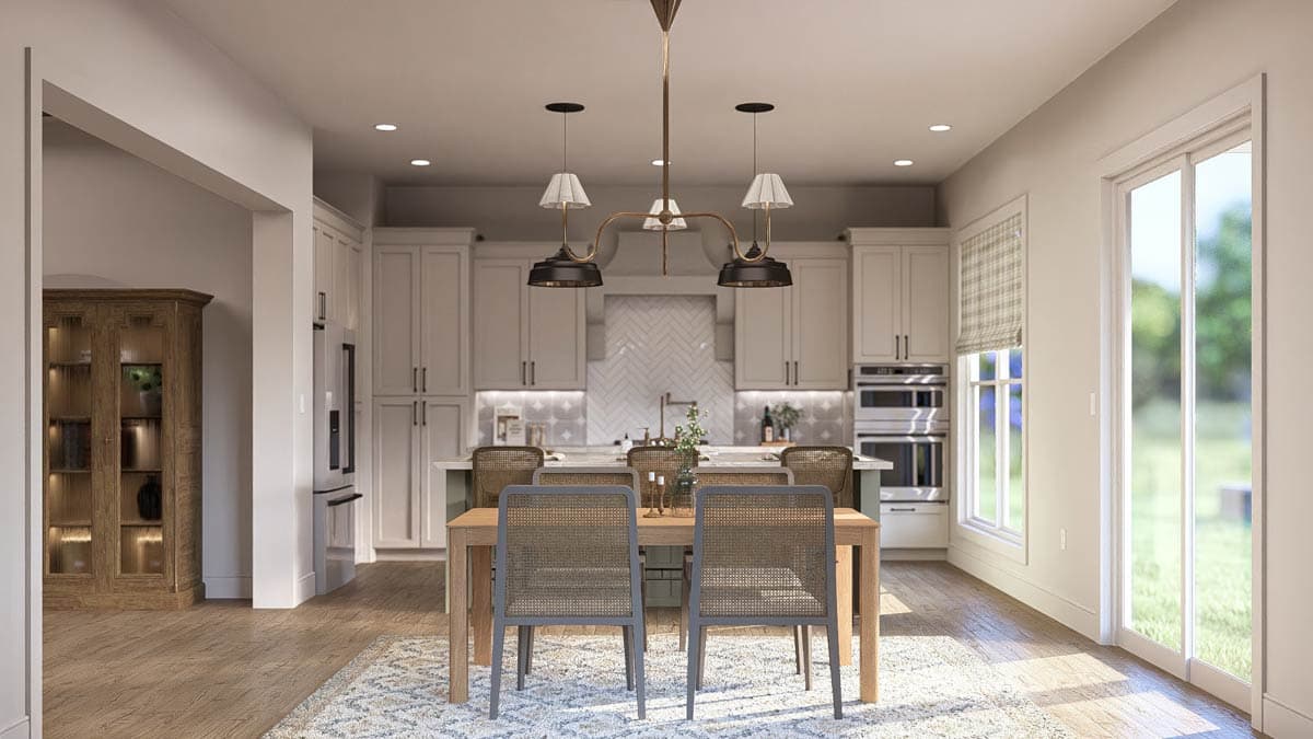 Modern kitchen and dining area with light gray cabinets, island, wood table, and large sliding glass doors.