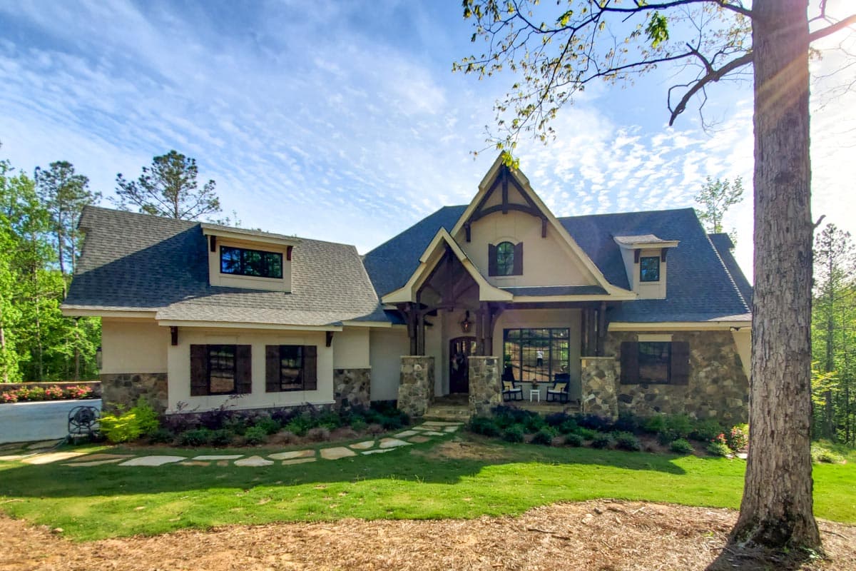 House plan exterior with Craftsman details, two stories, front porch, stone accents, and multiple gables.