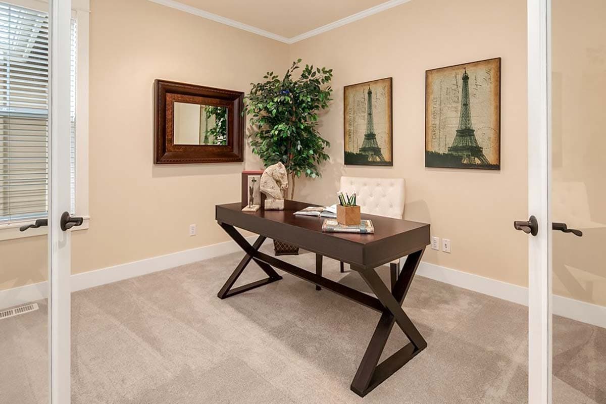 Interior office space with desk, mirror, plant, and artwork of the Eiffel Tower.