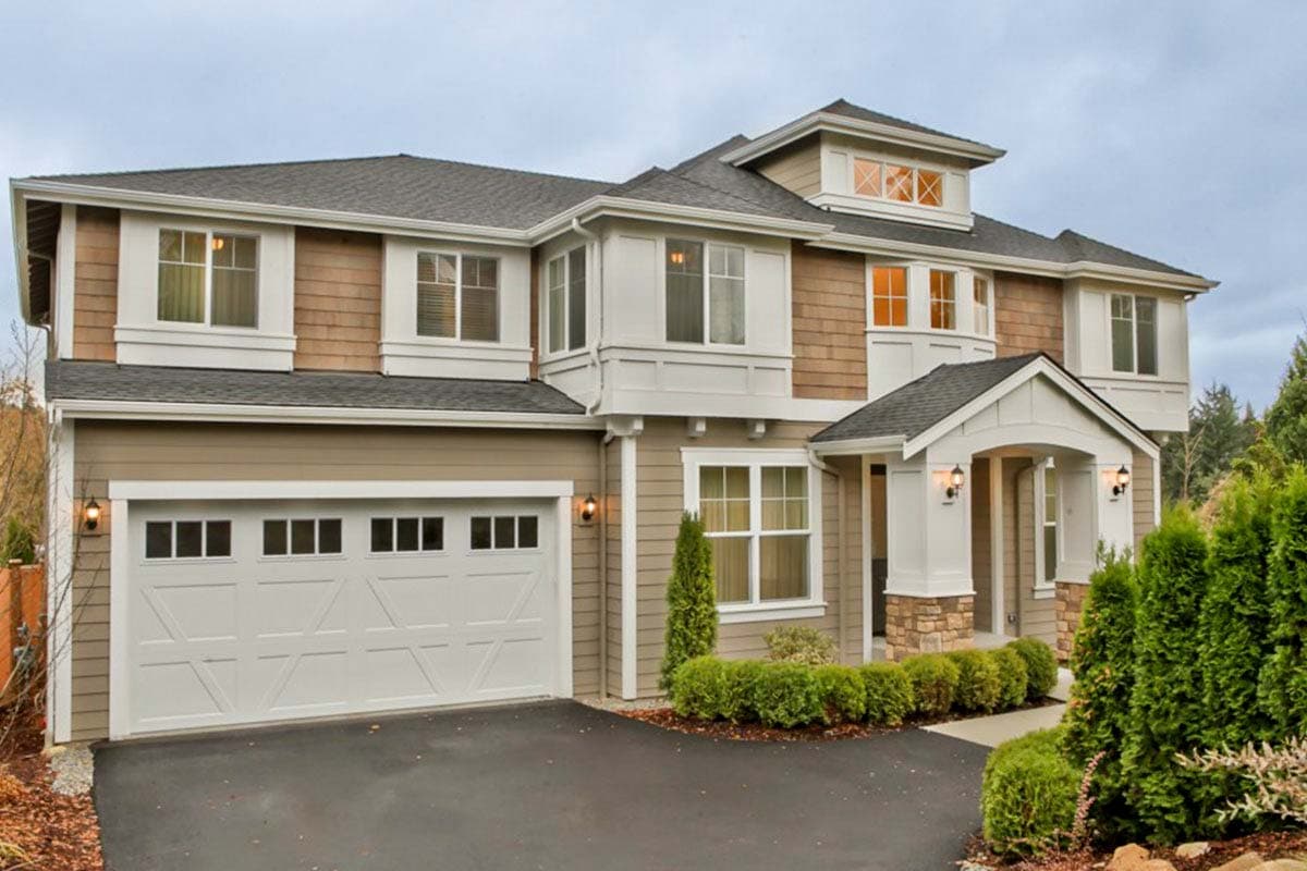 House plan exterior with two stories, a two-car garage, multiple gables, a covered porch, and a combination of shingle and siding exterior.