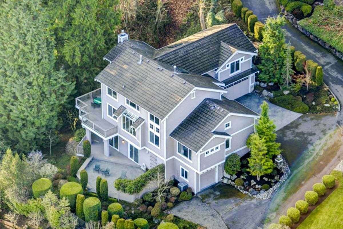 House plan exterior, two-story home with multiple gables, covered deck, and attached two-car garages.
