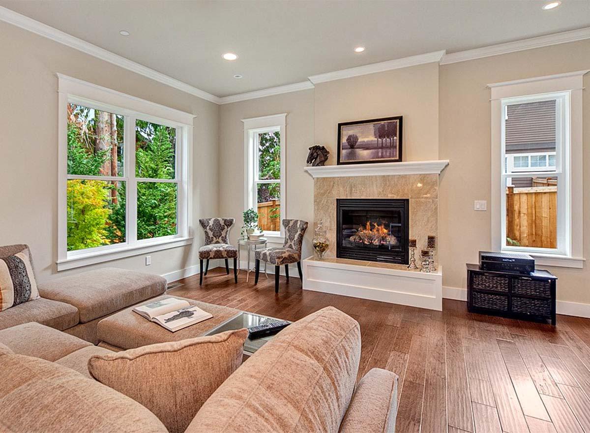 Living room with fireplace, large windows, and sectional sofa.