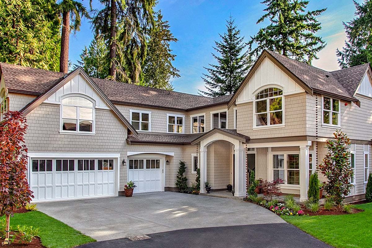 House plan exterior featuring two-story Craftsman style. Includes gabled rooflines, two-car garage, and covered porch entry.