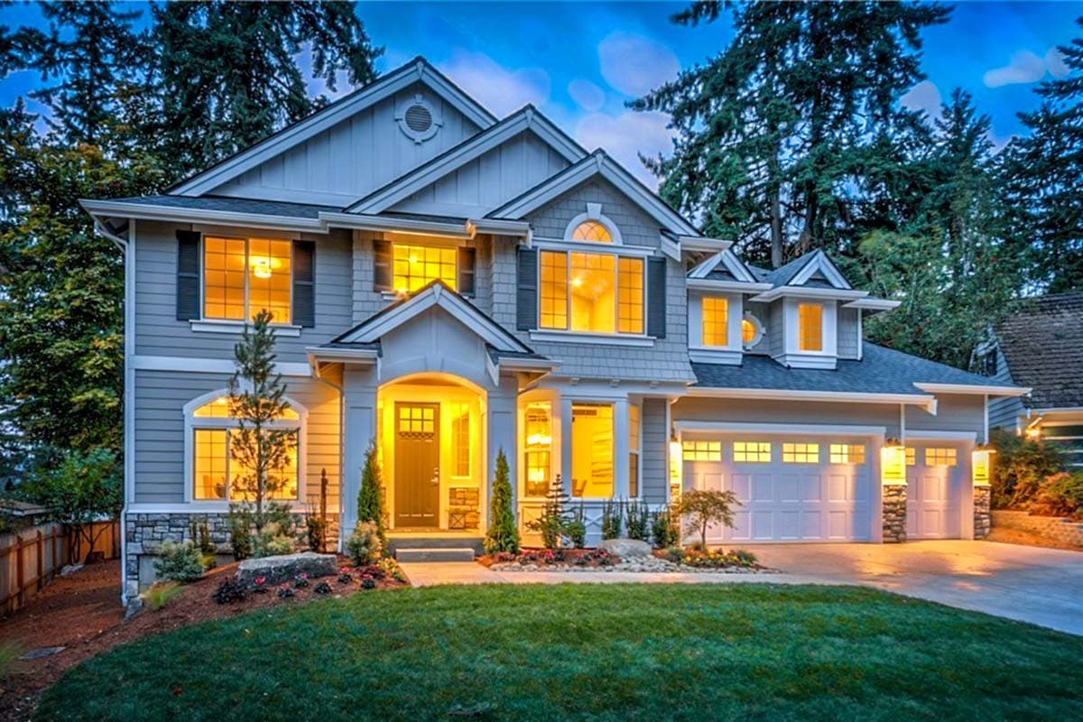 House plan exterior with two stories. Features include a front porch, gables, and a garage with overhead doors.