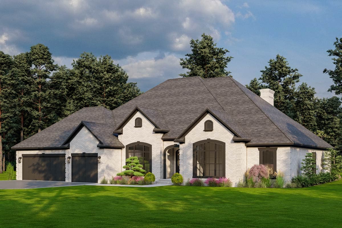 House plan exterior: Single-story home with white brick, arched windows, a prominent central gable, and a three-car garage.