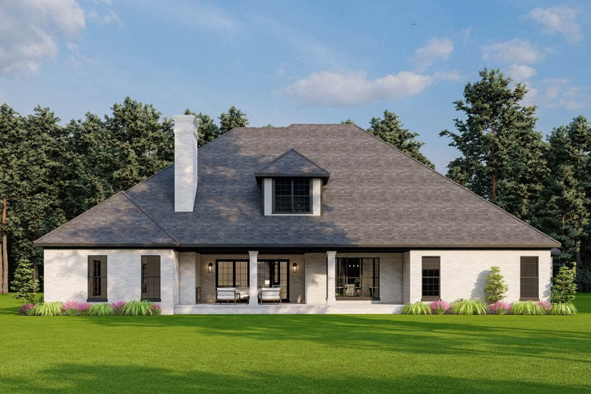 House plan exterior: White brick, one-story home with a large gable roof, prominent chimney, dormer window, and covered rear porch.